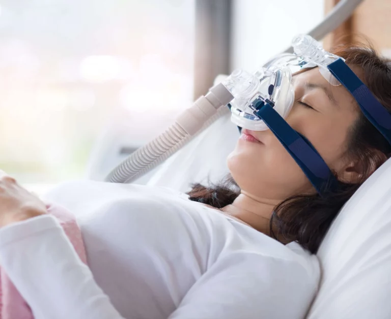 woman with CPAP mask on in hospital bed